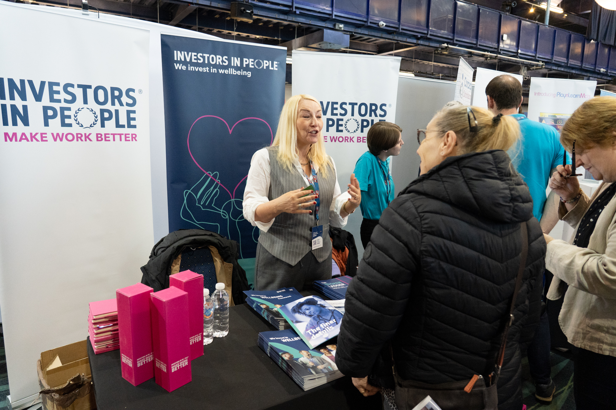 An exhibitor speaking with visitors at a previous careers expo